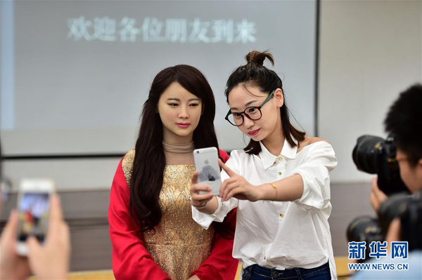 Robot Jia Jia (L) poses for a photo with a journalist at USTC.(Photo by Xinhua).jpg